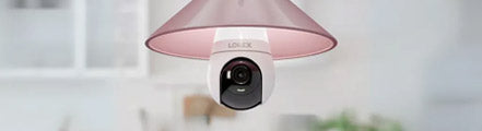 Lorex 2K Wi-Fi lightbulb security camera installed in a pink indoor ceiling fixture, offering smart surveillance and modern design for home monitoring.